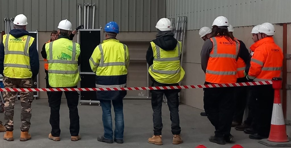 Construction workers in safety gear at a meeting.