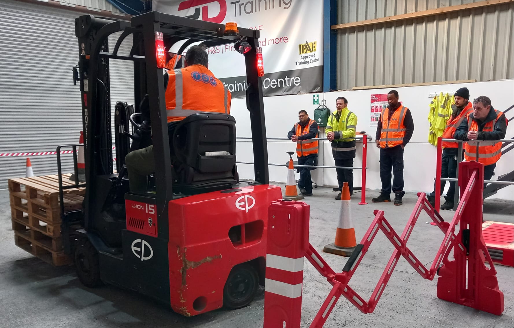 Forklift training session with safety group observing.